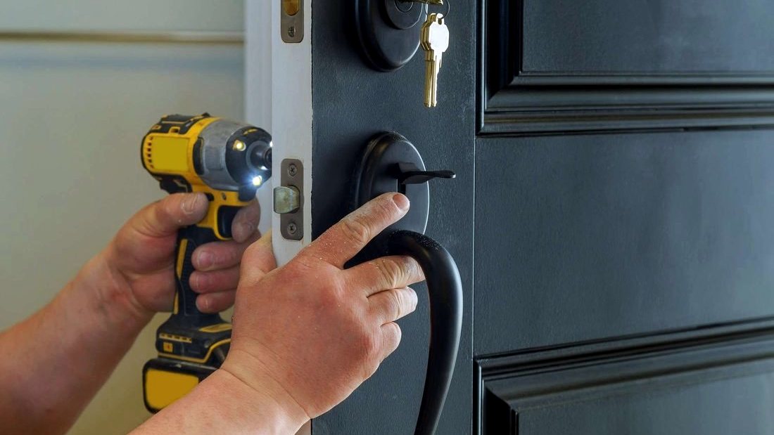 Locksmith fitting a deadbolt to a front door
