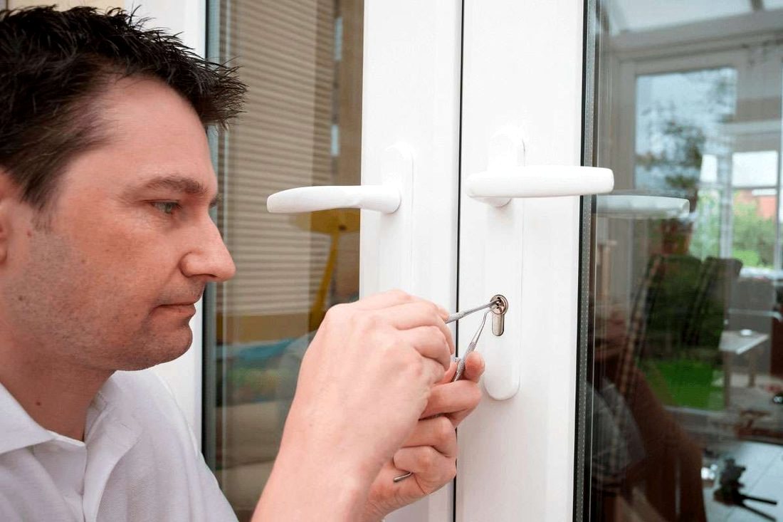 Locksmith inspecting a commercial glass door lock