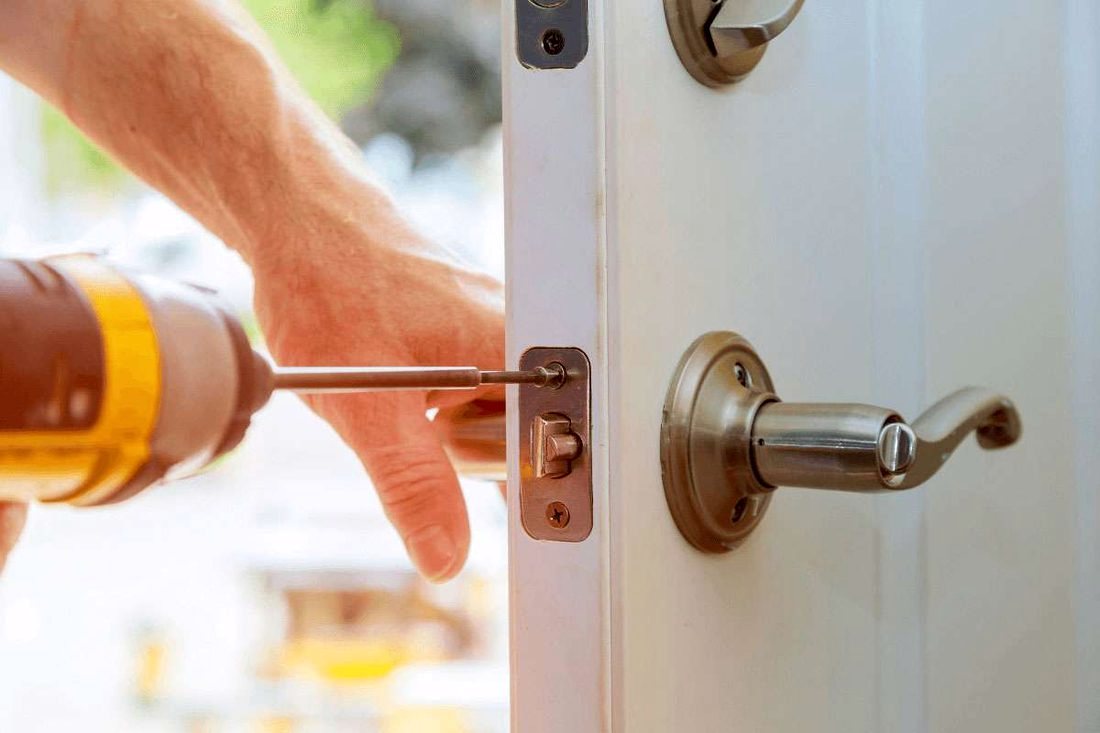 Locksmith fitting a lever lock to a door